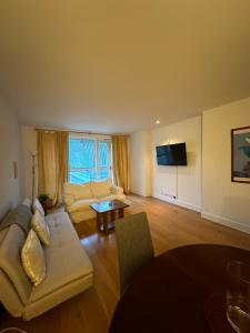 a living room with a couch and a table at Canary Wharf 1 bed apartment in London