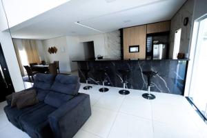 uma sala de estar com um sofá e um bar em Casa Temporada Campos do Jordão em Tremembé