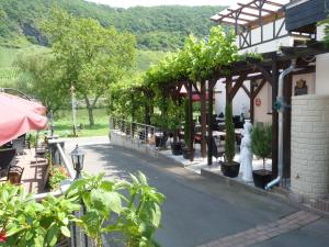 ein Gebäude mit einer Pergola mit Pflanzen darauf in der Unterkunft Moselperle Hotel Garni in Wolf