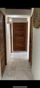 a hallway with a wooden door and a tile floor at Paulas Suites in Ixtapa