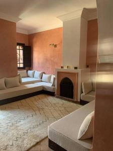 uma sala de estar com um sofá e uma lareira em Riad dar lamia em Marrakech
