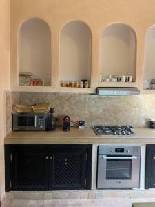 uma cozinha com um fogão e um micro-ondas em Riad dar lamia em Marrakech