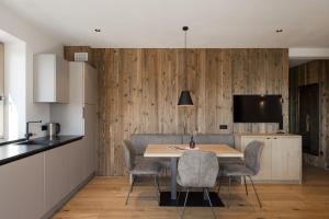 uma cozinha e sala de jantar com mesa e cadeiras em Apartsuites Rosengarten - New em Lagundo