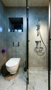 een badkamer met een douche, een toilet en een wastafel bij Lawendowe Domki Latoszyn-Zdrój Domek Bergen in Latoszyn