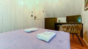 ein Zimmer mit einem Bett mit zwei Handtüchern darauf in der Unterkunft Lawendowe Domki Latoszyn-Zdrój Domek Bergen in Latoszyn