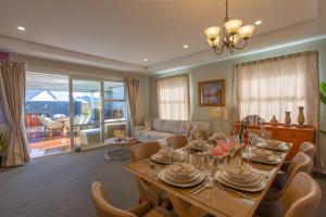 un soggiorno con tavolo da pranzo e sedie di Luxury Spa, Outdoor Fireplace & Games Room - Sleeps 10, 18 mins from CHC Airport a Prebbleton