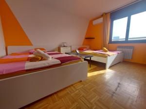 a bedroom with two beds and a table in it at Zagreb apartment Toni in Zagreb