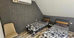 トビリシにあるKiev hotelのベッド2台と椅子が備わる客室です。