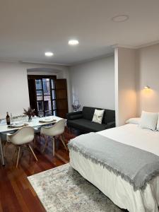 - une chambre avec un lit et une salle à manger dans l'établissement La mejor ubicación en Oviedo. Casco histórico., à Oviedo
