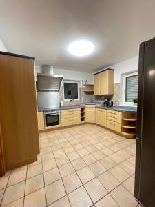 a large kitchen with wooden cabinets and a tile floor at Rheinview Sunset in Urbar in Urbar-Mayen-Koblenz