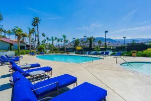 uma piscina com espreguiçadeiras azuis e uma piscina em Rancho Mirage Condo em Rancho Mirage