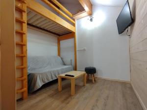 MieussyCocon Alpin - Praz de Lys Sommand的一间卧室配有一张床、一台电视和一张桌子