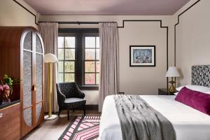 una camera con un letto e una sedia e una finestra di Zelda Dearest ad Asheville