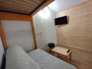 a bedroom with a bed and a table and a tv at Cocon Alpin - Praz de Lys Sommand in Mieussy