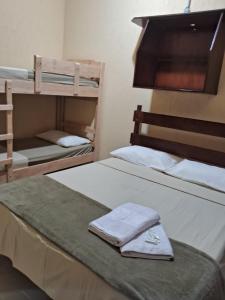 a bedroom with two bunk beds with towels on it at Pousada Sol e Lua in Caraguatatuba