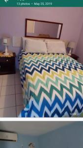 a bedroom with a bed with a colorful comforter at Cliff Apartment in Kingston