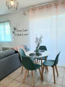 a living room with a table and chairs and a couch at Proche aéroport à pied, Le Rêve Rose. in Tillé