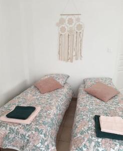 two beds sitting next to each other in a room at Proche aéroport à pied, Le Rêve Rose. in Tillé