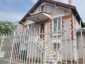 a white fence in front of a house at Charmante maison de 12 personnes près de Paris in Clamart