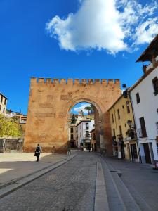 a person walking in front of an arch in a city at Apartamento Elvira in Granada