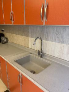 a sink in a kitchen with orange cabinets at جناح فاخر in Al Ahsa