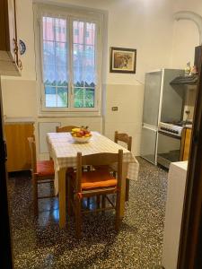 una cucina con tavolo e ciotola di frutta di LEONE VACANZE a Genova