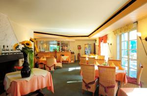 a restaurant with tables and chairs with flowers on them at Hotel Pontivy in Wesseling