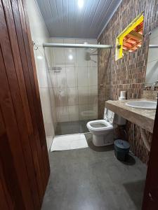 a bathroom with a shower and a toilet and a sink at Pousada Sunflower in Pirenópolis