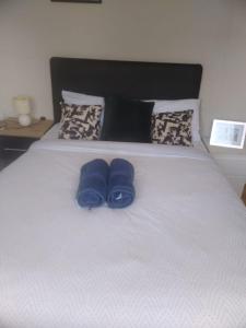 a pair of blue slippers sitting on a bed at The Comfy Cottage in Swords