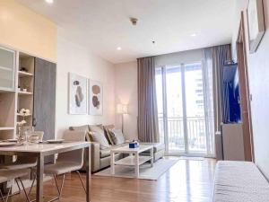 a living room with a couch and a table at Expansive Modern - BTS Phrom Phong - Ultra Fast WiFi in Khlong Toei