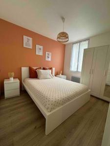 1 dormitorio con 1 cama grande y paredes de color naranja en cosy mery, en Méry-sur-Oise