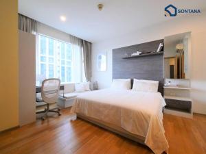 a bedroom with a bed and a desk and a chair at Expansive Modern - BTS Phrom Phong - Ultra Fast WiFi in Khlong Toei +8 photos