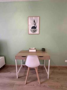 Habitación con escritorio de madera y silla rosa. en cosy mery, en Méry-sur-Oise