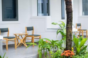 un patio con sillas, una mesa y una palmera en NatalieLe's Homestay, en Phu Quoc