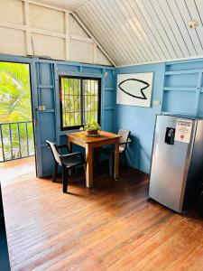 ein Esszimmer mit einem Tisch und einem Kühlschrank in der Unterkunft Surf Paradise in Playa Santa Teresa