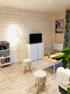 a living room with a tv and a table and chairs at Maison 4 p. Château de la Loire in Sonzay