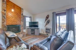 ein Wohnzimmer mit einem Ledersofa und einem Kamin in der Unterkunft Cozy Angel Fire Condo Walk to Ski Lift! in Angel Fire