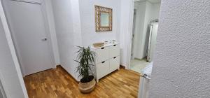 a room with a dresser and a mirror and a plant at Apartamento Gómez in Caravaca de la Cruz