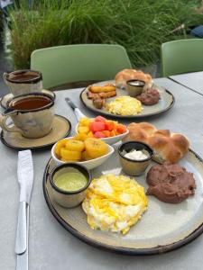 a table with three plates of breakfast food on it at BOURBON HOSTAL in Juayúa