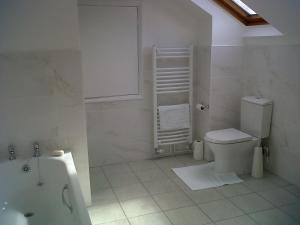 La salle de bains est pourvue de toilettes et d'une baignoire. dans l'établissement The Coach House, à Shepreth