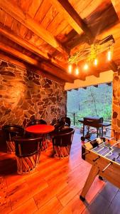 a room with a table and chairs and a stone wall at Cabaña Luna Encantada in Mazamitla