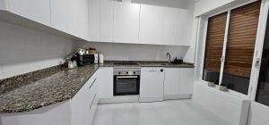 a kitchen with white cabinets and a stove top oven at Apartamento Gómez in Caravaca de la Cruz +21 photos