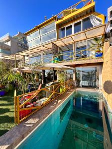 a house with a swimming pool next to a building at Pacificsunset Reñaca in Viña del Mar