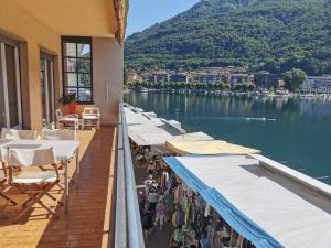 a group of tables and umbrellas on a balcony with a lake at Lakefront 15 in Omegna