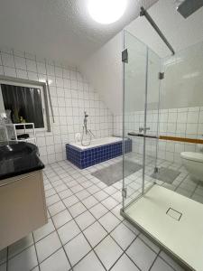 y baño con ducha, bañera y lavamanos. en Rheinview Sunset in Urbar, en Urbar