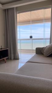 um quarto com uma cama e vista para o oceano em Apartamento Frente Mar em Vila Velha