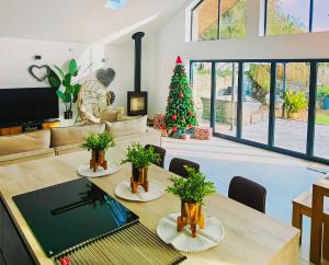 a living room with a table and a christmas tree at CORNWALL LUXURIOUS UNIQUE New Build PALMA VILLA# 4miles EDEN PROJECT, BEACH & HARBOUR # Private Location, Encllosed Garden with View, Underfloor Heating, Coffee Machine# Walking-Cycling Path, Pet Friendly in St Austell