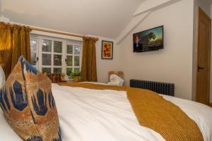 a bedroom with a bed and a tv on the wall at The Brasenose Arms in Banbury
