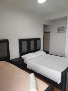 Catia La MarにあるPosada Restaurant La Guarichaのベッドルーム1室(白いシーツが備わるベッド2台付)