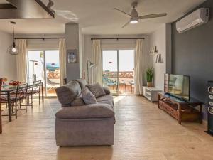 a living room with a couch and a television and a table at Apartamentos Chimenea in Nerja